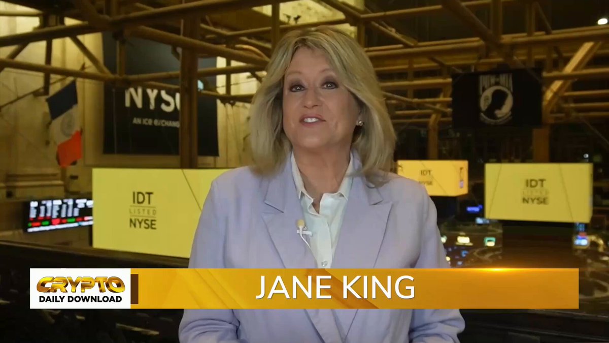 The image features a woman wearing a purple blazer standing in front of a TV screen displaying a news segment about cryptocurrency. The news anchor is discussing the transparency efforts by the Market Jane Alliance, which aims to establish standardized token disclosures for ICOs (Initial Coin Offerings). This information is relevant to the Crypto Daily download that was posted on social media platforms. The image also includes text elements such as "Crypto Daily Download" and "@MarketJane".