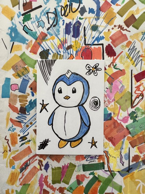 A small painting of a cute blue penguin with stars and a butterfly, signed by the artist, resting on a larger abstract painting covered in colorful brushstrokes and the word 'DAD'.