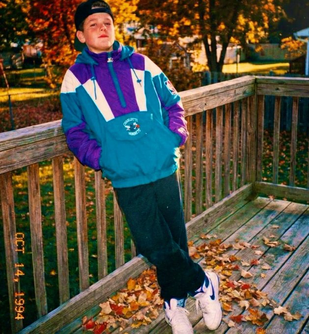 A young person poses on a wooden deck wearing a teal and purple Charlotte Hornets pullover jacket, with an "OCT 14 1994" timestamp visible in the corner. The vintage sports apparel and autumn setting capture a nostalgic moment, while the post's reference to a stolen item likely alludes to the collectible value of the dated '90s-era team jacket.