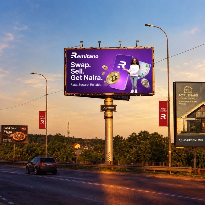 Outdoor billboard advertising "Remitano - Swap. Sell. Get Naira. Fast. Secure. Reliable." featuring Bitcoin imagery, located above a road alongside other billboards for a pizza ad and Royal Estates.