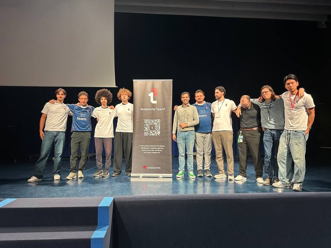 A group of ten people pose on a stage around a banner for the 'Avallone Team' with a QR code and text about privacy and global challenges.
