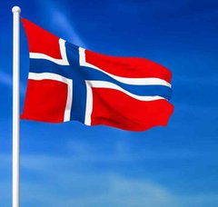 The national flag of Norway, featuring a red field with a blue Scandinavian cross outlined in white, waving against a blue sky.