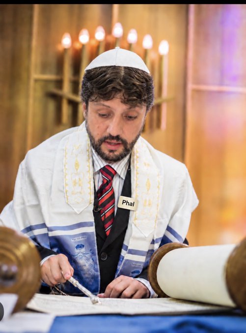 A Jewish man wearing a white kippah and tallit, with a name tag reading "Phal," reads from a Torah scroll in front of a menorah. The image humorously relates to the post's mention of "Jeff," possibly parodying a solemn or random draw announcement with a religious ceremony aesthetic.
