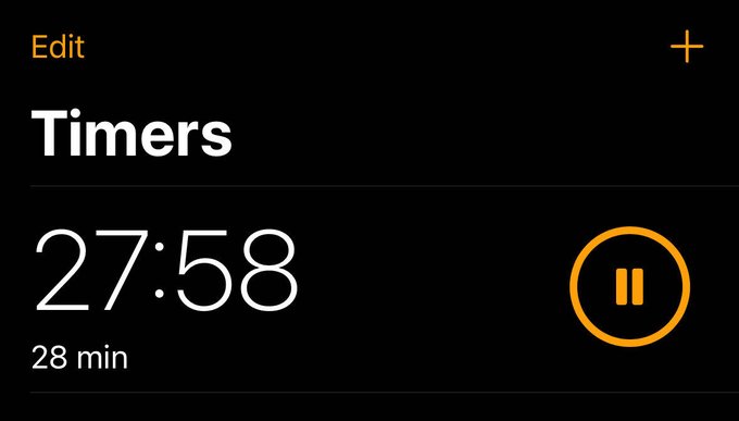 An iOS Timer app screenshot displays a 28-minute countdown timer currently paused at 27:58 remaining, matching the post's playful ultimatum giving 27 minutes to download Coinbase.