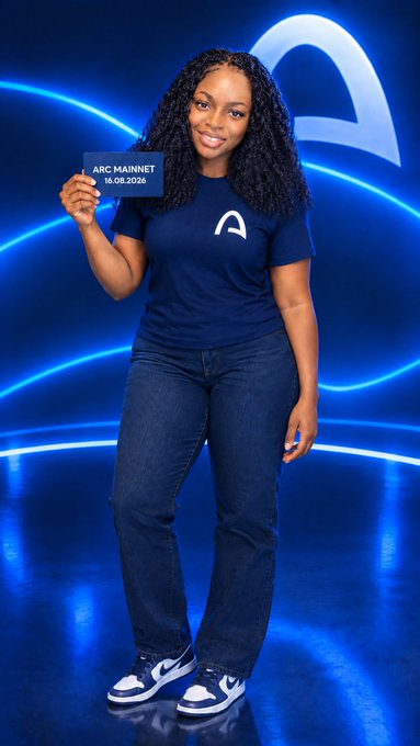 A woman wearing a blue t-shirt with an 'A' logo and jeans, holding a card reading 'ARC MAINNET 16.08.2026' against a blue background with the Arc logo.