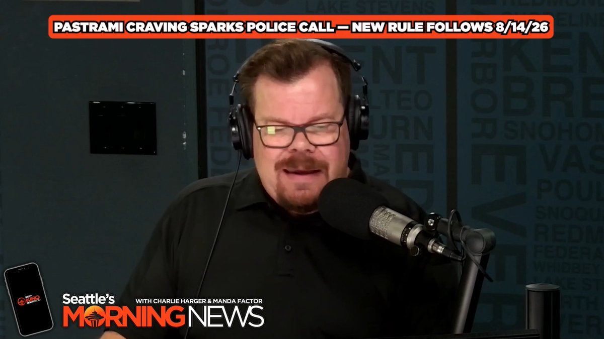 A radio host with headphones and glasses speaks into a microphone on Seattle's Morning News, with a headline about a pastrami craving sparking a police call and new rule from August 14, 2026.
