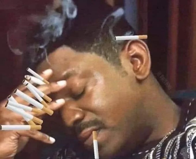 A man holds numerous lit cigarettes with smoke billowing around his face. The image humorously illustrates the post's critique of DCA (Dollar-Cost Averaging) in Bitcoin, comparing the overwhelming intensity of excessive habits to blindly accumulating BTC without strategy.