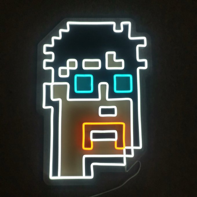 Neon sign depicting a stylized geometric figure with cyan square eyes and an orange mouth, mounted on a dark wall.