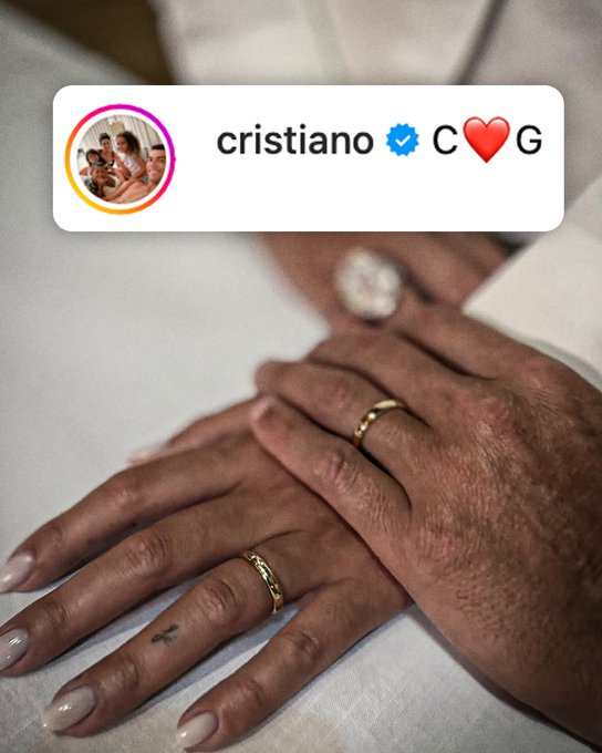 The image shows a close-up of two hands clasped together, with the larger hand (appearing to be Cristiano Ronaldo's) wearing a gold ring, resting on a smaller hand. An Instagram-style profile header displays "cristiano" with a verified checkmark and "C❤️G" (likely representing Cristiano and Georgina), referencing the post's complaint about an organization allegedly editing out the ring—which symbolizes Ronaldo's engagement to Georgina Rodríguez.