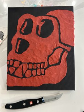 A red and black linocut print of a skull next to a carving knife.