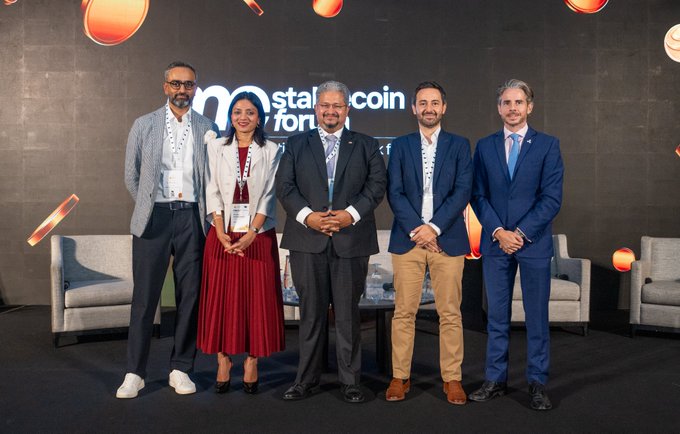 Five individuals pose together on stage at an "Ostali Forum for" event, with a backdrop displaying partial text suggesting "Ostali Coin Forum." The post indicates the gathering involves a senior Ripple executive alongside representatives from BlackRock and HSBC, suggesting this formal panel features leaders from the crypto, asset management, and banking sectors.