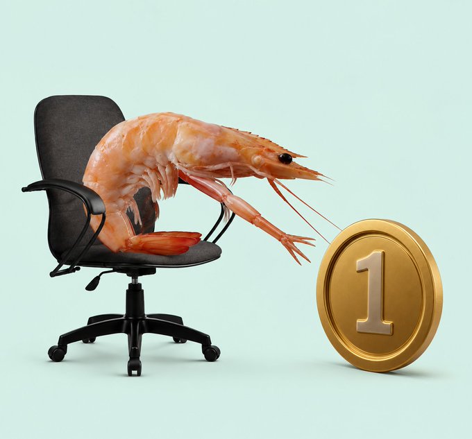 A surreal image shows a large pink shrimp seated on a black office chair, using its claws to hold up a golden coin marked with the number "1" against a pale mint green background.
