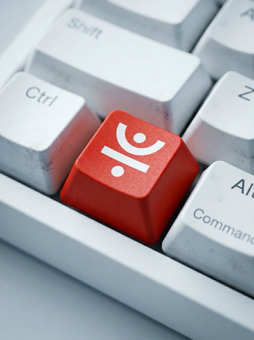 A close-up of a white mechanical keyboard highlighting a red keycap printed with the white IOGames.io (IO) logo, positioned between the Ctrl and Command keys.