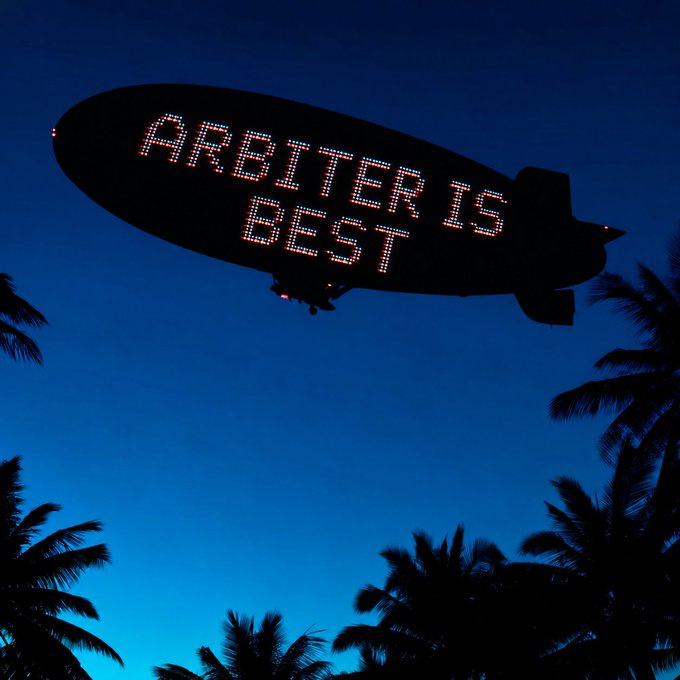A digital blimp illuminates the night sky with the LED text 'ARBITER IS BEST' above silhouetted palm trees.