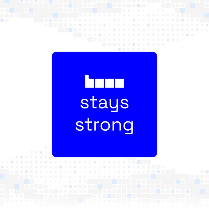 A blue rounded-square logo features a stylized white icon resembling blocky buildings or pixels above the stacked white text "stays strong." The design visually reinforces the accompanying message "Base stays strong.🔥," echoing its theme of resilience.