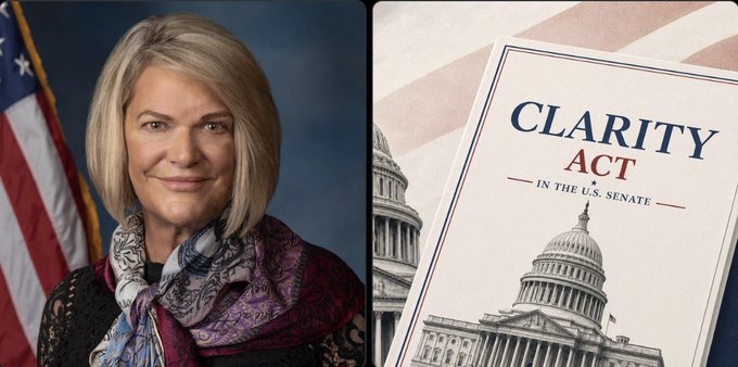 A woman with blonde hair wearing a patterned scarf poses in front of an American flag, alongside a document titled "CLARITY ACT - IN THE U.S. SENATE" displayed over an image of the Capitol building, illustrating the new draft of the Crypto Clarity Act mentioned in the post.