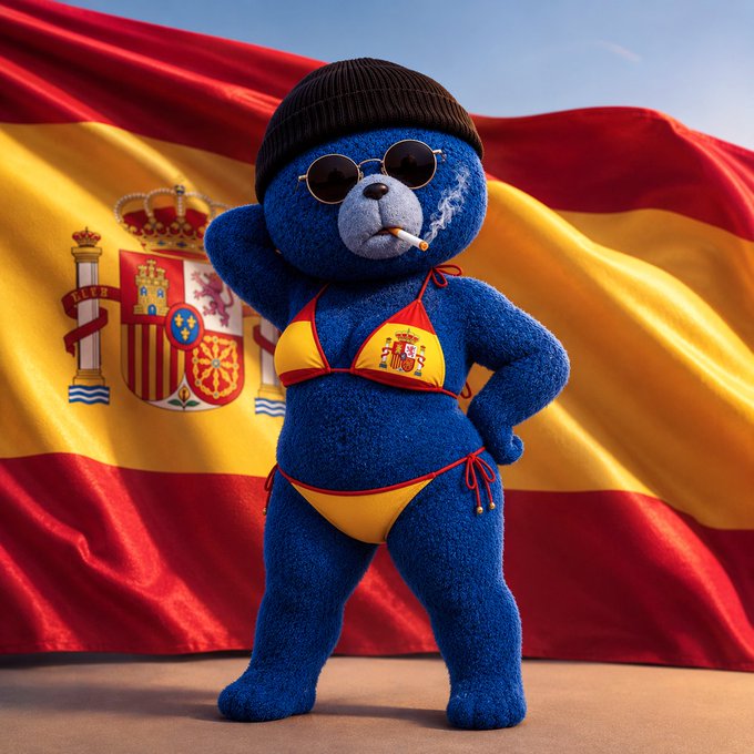 A blue teddy bear wearing a black beanie, sunglasses, and a yellow-and-red bikini top smokes a cigarette in front of a waving Spanish flag bearing the national coat of arms. The image's bold, irreverent character contrasts with the caption's fragmented web3 slang, suggesting a playful or chaotic post meant for crypto community audiences.