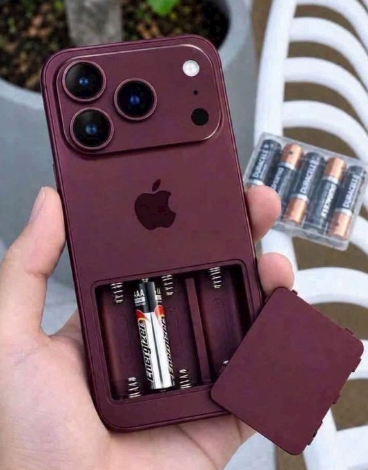 A hand holds a dark red smartphone case with a removable compartment revealing AA and AAA Energizer batteries, with a pack of batteries visible in the background.