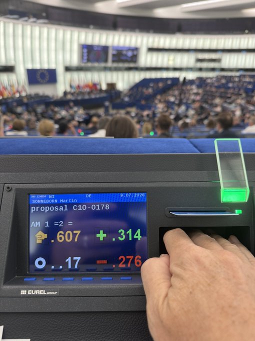 An EU Parliament voting terminal displays an amendment by Sonneborn (Martin) on proposal C10-0178, with results showing 607 in favor, 314 against, 17 abstentions, and 276 not voting on 6.07.2024. The image captures a delegate's hand operating the terminal during a plenary session, visually reinforcing the post's lament about democratic processes in Europe and concerns over surveillance overreach.