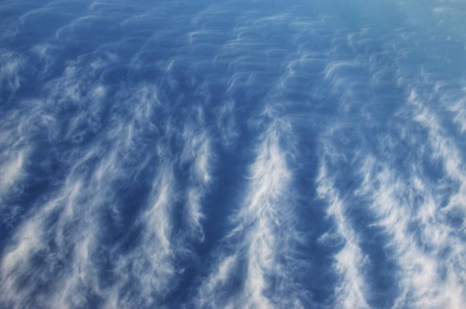 A blue sky with wispy, feathery cirrus clouds spread across it.