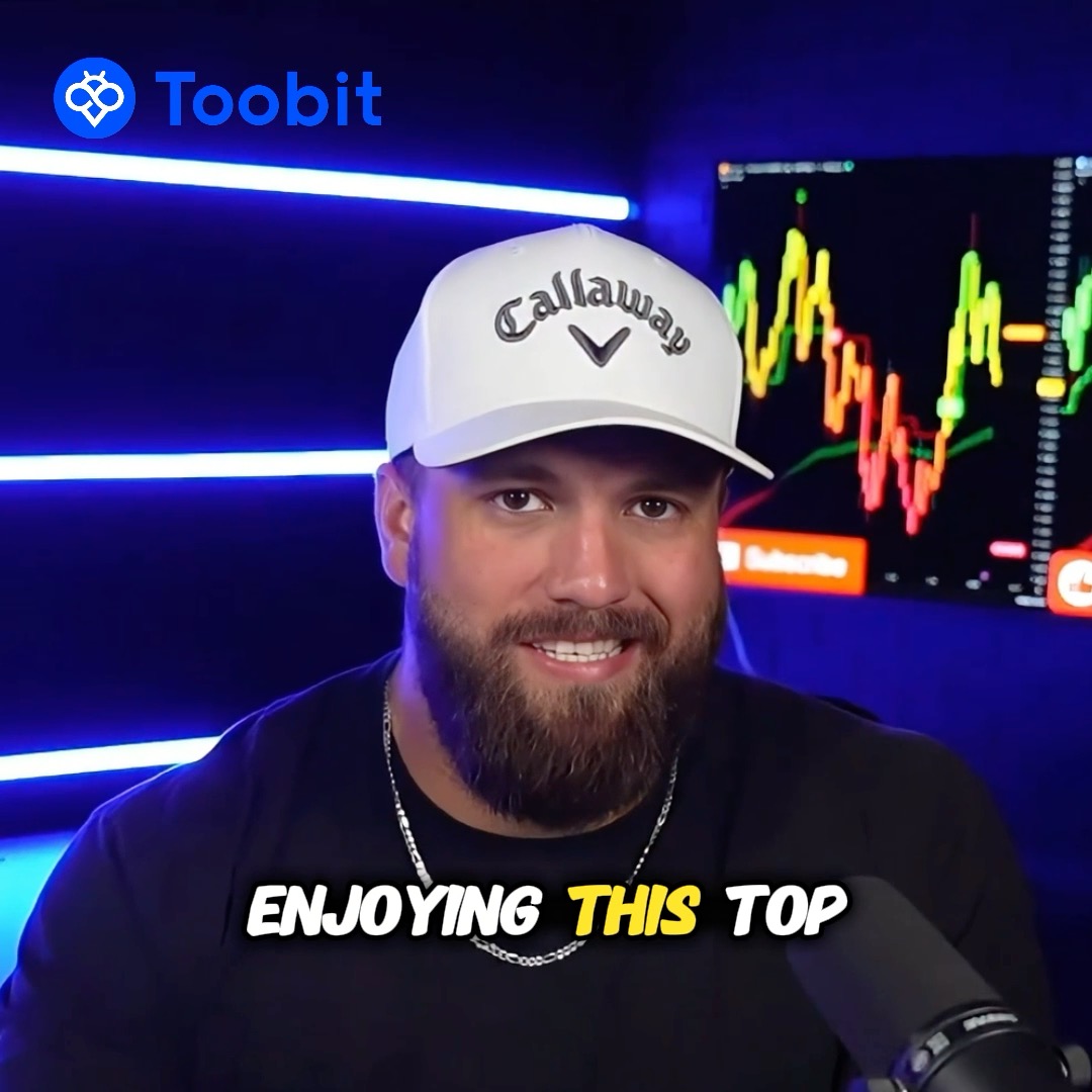 A bearded man wearing a white Callaway cap and dark t-shirt speaks in front of a cryptocurrency trading chart, with a Toobit logo visible in the top left corner.