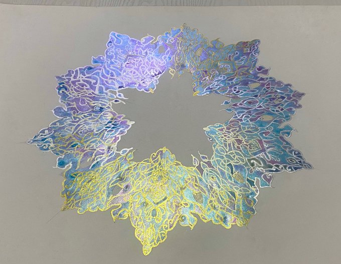 A circular, wreath-like abstract artwork featuring swirling iridescent patterns in blues, purples, and yellows on a pale gray background. The post indicates this generative art piece is available for purchase on the objkt.com marketplace.