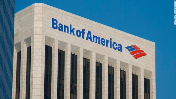 The image shows a Bank of America building facade with the company's distinctive red and blue flag logo, directly representing one of the major U.S. financial institutions reportedly part of the consortium (along with JPMorgan and Wells Fargo) exploring a joint stablecoin issuance.