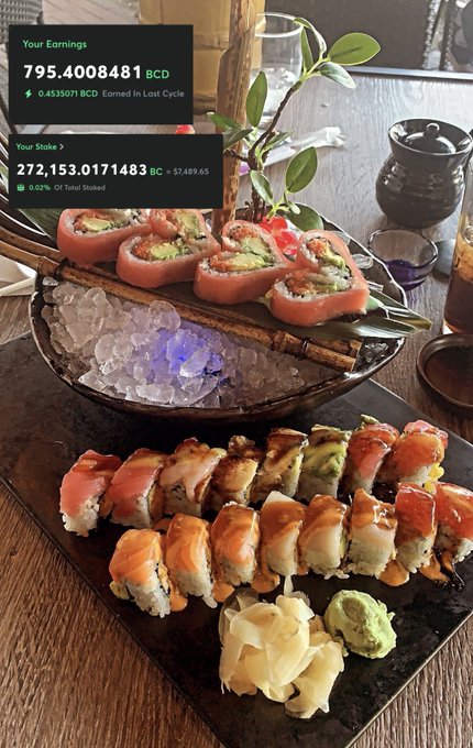 A sushi platter displayed on ice and a black tray, showing various rolls with tuna and avocado, garnished with ginger and wasabi, alongside an overlay showing crypto earnings and staking information.