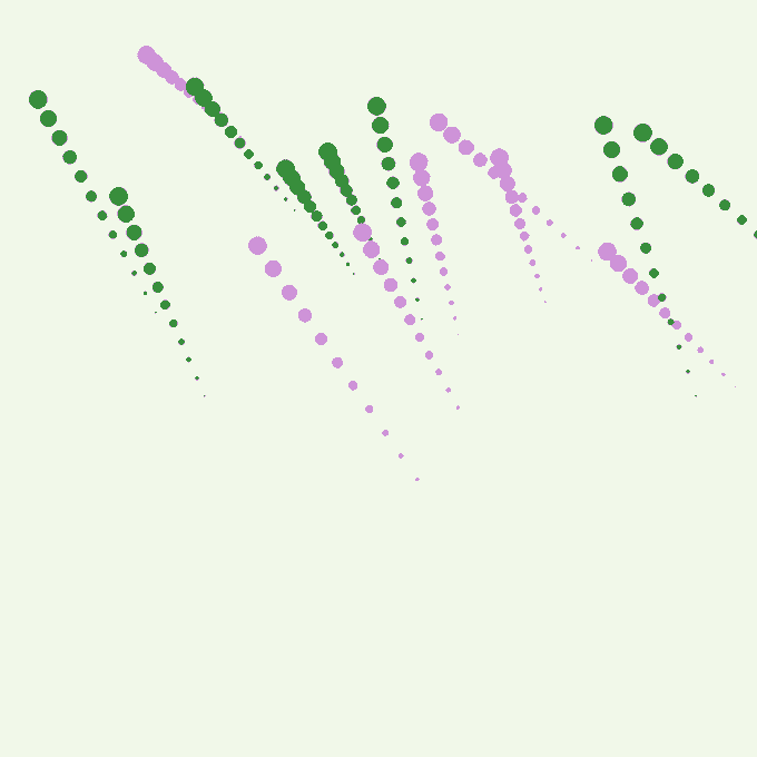 An abstract pattern of green and pink dotted diagonal lines arranged in a chevron/zigzag design on a white background.