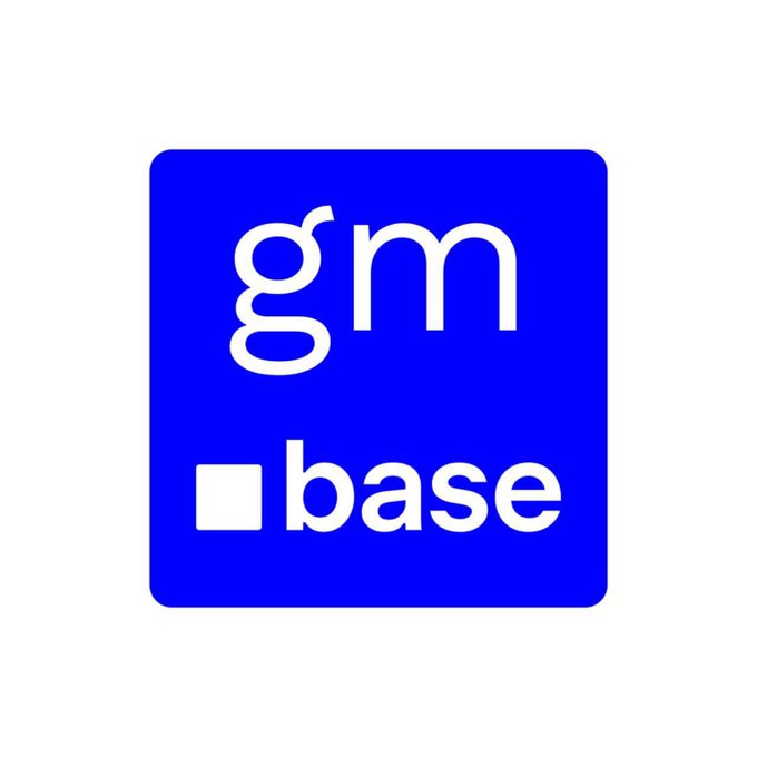 The image features a square blue logo with white text that reads "GM GM Base" written in all capital letters, positioned centrally within the frame. The background of the image is white, which makes the blue logo stand out prominently.