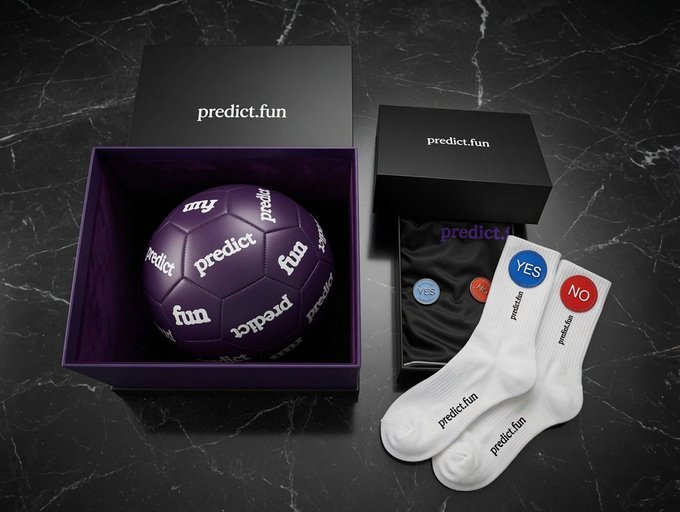 Premium merchandise packaging from 'predict.fun' featuring a purple soccer ball in a box, accompanied by black drawstring bags and white branded socks with 'YES' and 'NO' tags.