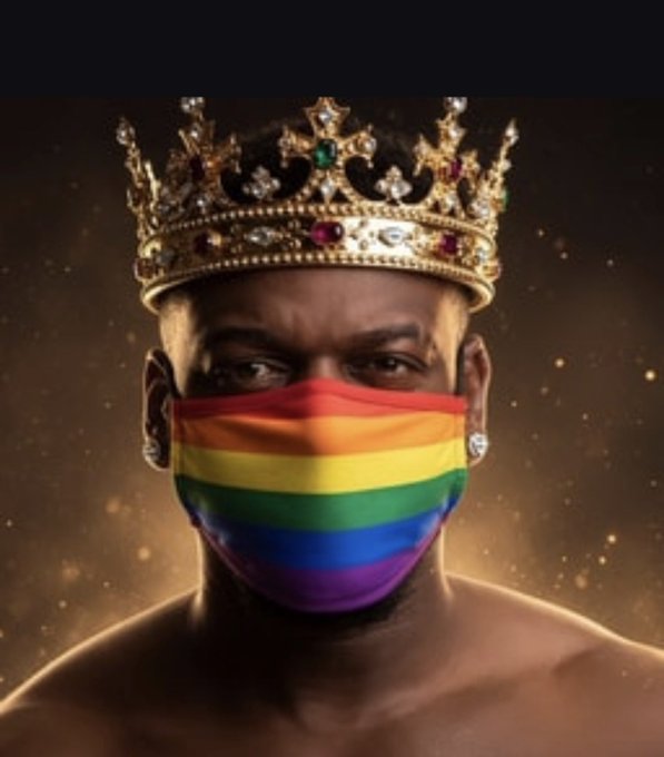 A Black man wears a jeweled golden crown and a rainbow Pride face mask against a warm, sparkly background.