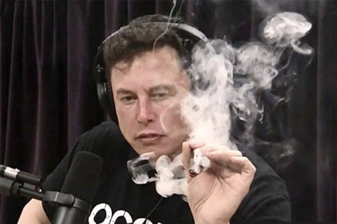 A man wearing headphones and a black "OCCUPY" t-shirt smokes a cigarette while speaking into a podcast microphone. The accompanying post criticizes the app's owner—referring to Elon Musk—accusing him of trolling, farming engagement, and spreading misinformation.