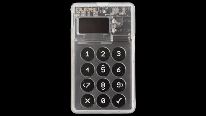 A close-up product shot shows a transparent 'COLDCARD' hardware wallet with a numeric keypad and a small screen, set against a black background.