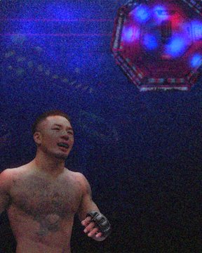 A tattooed fighter wearing a UFC glove looks up in the arena, as a UFC logo hovers in the background.