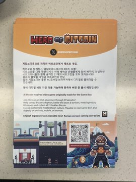 A promotional flyer for "Hero of Bitcoin" displayed at ORIGINSEOUL, featuring pixel-art style game imagery, a QR code, and text announcing its official partnership with the conference along with the release of a Korean version running only once.