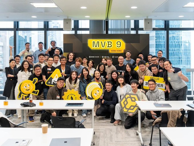 A large group of people pose for a group photo at a 'MVB 9 HONG KONG' event, with some holding up logos for BNB CHAIN, CELDA, and Coinbase.