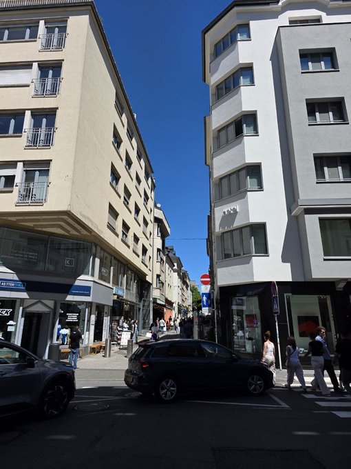 A sunny European street scene with pedestrians and a black car at an intersection, featuring a "Do Not Enter" sign and storefronts with awnings.

The image shows a bright, everyday morning street view—fitting the post's message about cherishing each day and not missing the opportunity (work/payout) it brings.