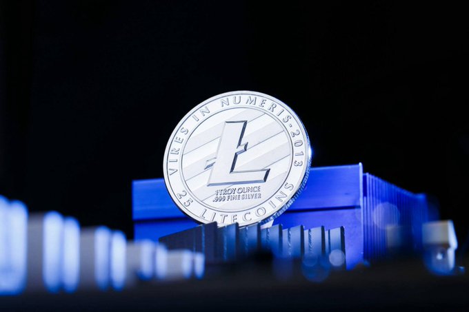The image features a silver coin with the word "LTC" written on it, placed on top of a blue box or container. The background appears to be black, which contrasts with the white lettering on the coin. The text "LTC has quietly built one of the most reliable networks in crypto Fast transaction, low fees and over a decade of uptime Litecoin keeps doing what it was built for" is written below the coin. This message seems to be related to the coin or its use within the cryptocurrency world.