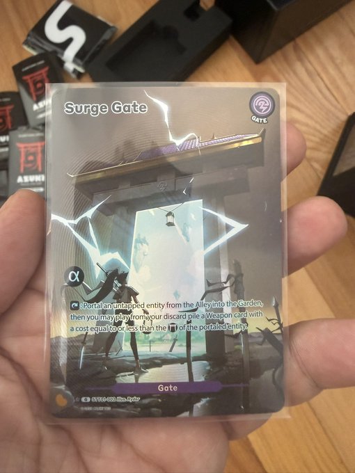 A hand holds a holographic trading card titled "Surge Gate" depicting a portal and an archer, with text including "Portal an untapped entity from the Alley into the Garden".
