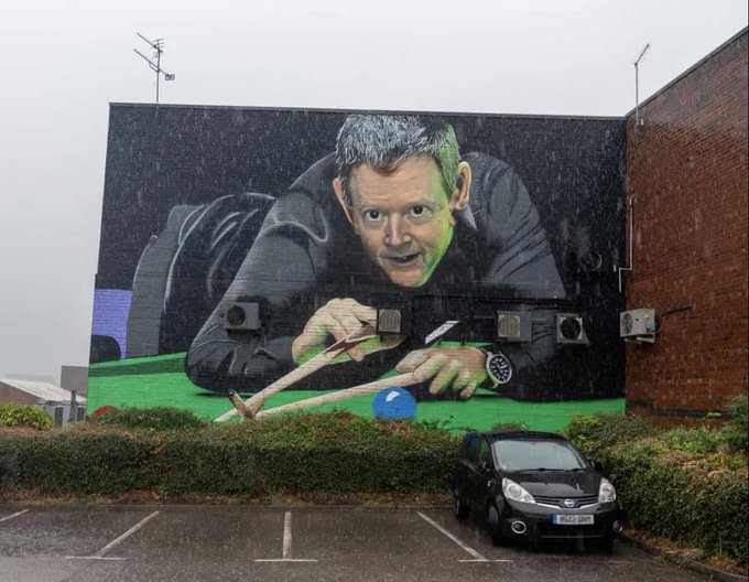 A massive mural painted on the side of a building depicts a man leaning over a green snooker table with a cue stick, while a small black car (license plate FG58 KFK) is parked below in a wet lot. The image relates to the post "Jobs not finished" by visually showing an incomplete snooker shot, with the man seemingly about to take his turn but the job left undone, humorously tied to the ticker references $PNDC and $wPOND.