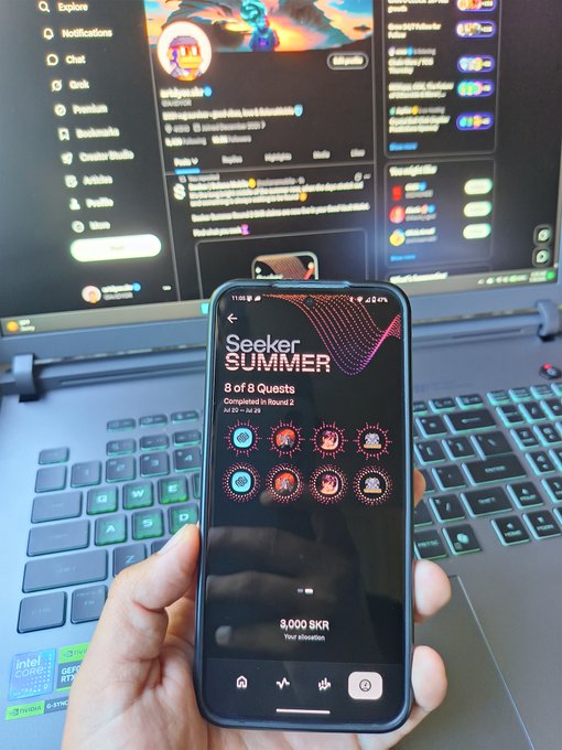 Hand holding a phone displaying 'Seeker Summer' with 8 of 8 quests completed in Round 2, showing a 3,000 SKR allocation in front of a laptop.