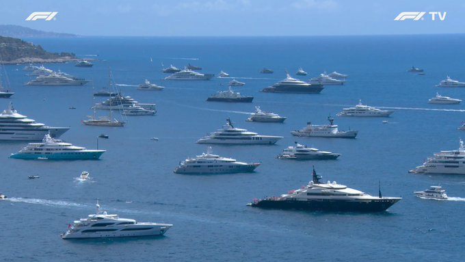 The image shows an aerial view of a large body of water with numerous boats, including yachts and luxury liners. The boats are scattered across the water, creating a sense of depth and scale. In the background, there is text that reads "To reiterate, buying $neet is not about unemployment Buying $neet is a way of expressing the view that the relationship between labour and prosperity is broken This will continue to gather pace". The boats in the image seem to represent different aspects of life or society, with some boats appearing more luxurious than others. The presence of these boats on the water could symbolize the diverse range of experiences people have when it comes to their financial situations and how they choose to spend their money.