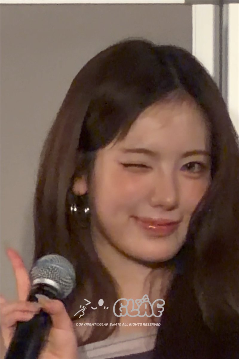 A close-up of a smiling woman winking and holding a microphone, with a watermark reading "COPYRIGHT©GLAF_Sui410 ALL RIGHTS RESERVED" visible at the bottom.