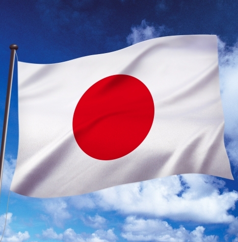 The Japanese national flag, featuring a red circle on a white background, waves against a partly cloudy sky. This image symbolizes Japan's recent imposition of new sanctions on Russia, which included asset freezes targeting entities like the cryptocurrency exchange Garantex.