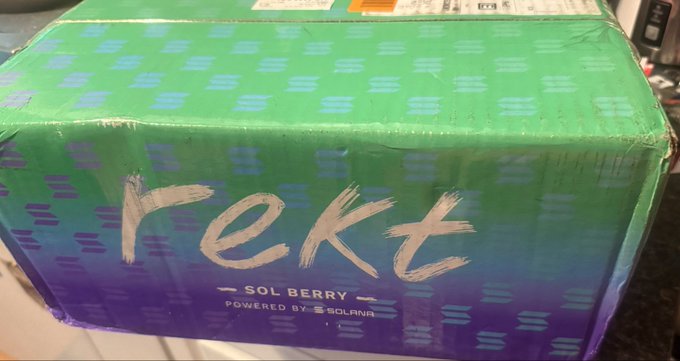 A green and purple gradient cardboard box with 'rekt' written in white brush-stroke lettering, labeled 'SOL BERRY' and 'POWERED BY SOLANA' underneath.
