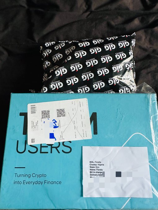 The image shows a package from GIG Logistics being unboxed, with "GIG" repeated on the black packaging and "Turning Crypto into Everyday Finance" visible on the blue box below, relating to the @BitgetWallet PR package.