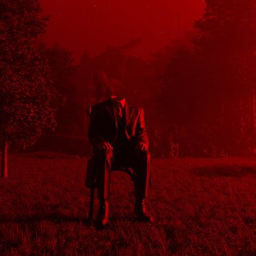 A silhouette of a person sitting on a chair in a field, bathed in an eerie, intense red light.