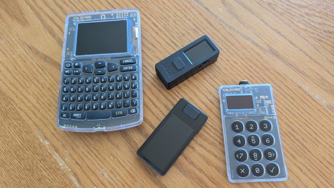Four small, transparent electronic devices labeled "CXG.CARD" are arranged on a wooden surface, including a pocket computer with a QWERTY-style keyboard, a numeric keypad, and two rectangular modules. The caption relates to the user's self-deprecating post by visually representing the feeling of being outsmarted or humbled, as these "calculator" and "computer" gadgets—designed by a notorious cheating ring—make even basic math seem brain-dead simple.