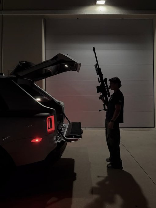 A silhouette of a man holding a large sniper rifle stands next to an SUV with its trunk open in a dimly lit garage, evoking a dramatic "end of day" vibe that matches the post's "Good night" farewell to followers of the @EVEDEX project.